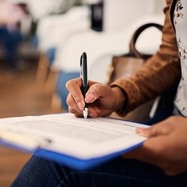 Woman filling out dental insurance form in lobby