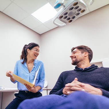 Dentist viewing X-ray with smiling patient