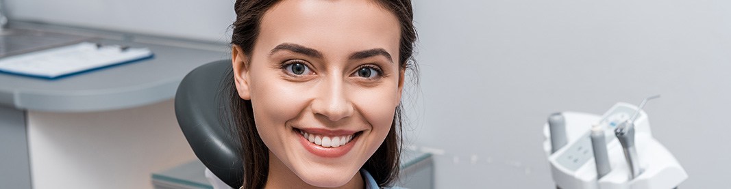 A beautiful woman sitting and smiling in a dental clinic