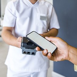 A dental patient using a smartphone to pay for dental care