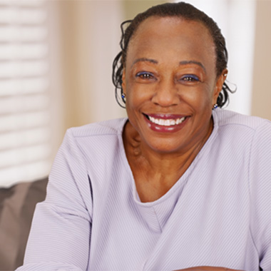 Smiling patient talking to dentist while sitting in treatment chair